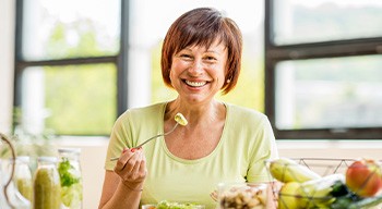 Somerville patient eating healthy meal with dentures