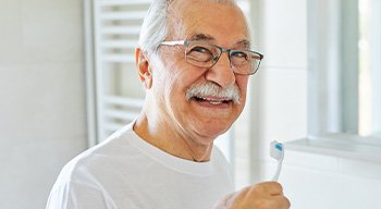 Denture patient in Somerville brushing remaining teeth