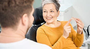 a patient pointing to a dental model