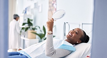 Woman smiling while looking at reflection in mirror