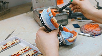 Lab tech creating wax version of dentures